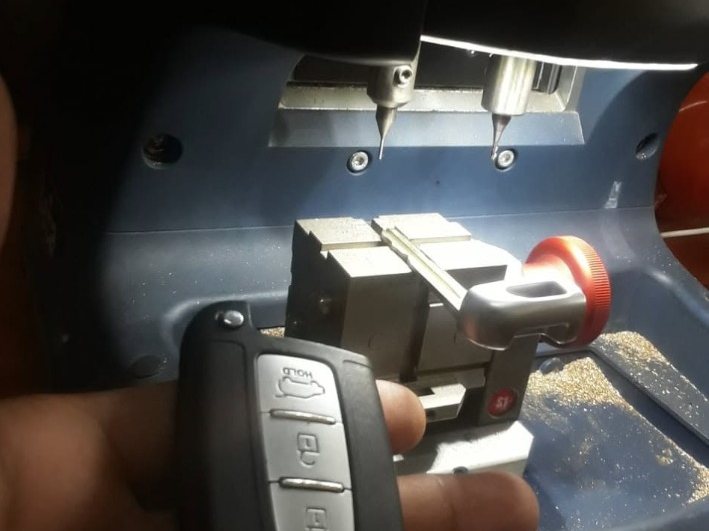 Ekasi Locksmith cutting a car key and remote.